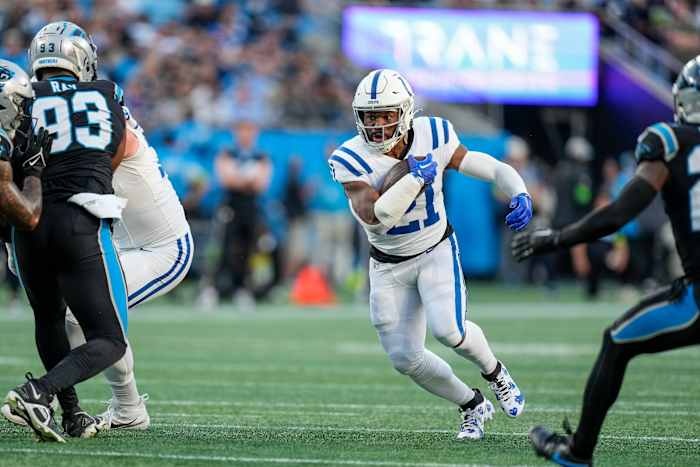 Nov 5, 2023; Charlotte, North Carolina, USA; Indianapolis Colts running back Zack Moss (21) runs through an opening defended by Carolina Panthers defensive tackle LaBryan Ray (93) during the first quarter at Bank of America Stadium. Mandatory Credit: Jim Dedmon-USA TODAY Sports